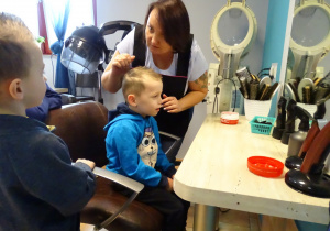 chłopiec na krześle u fryzjera